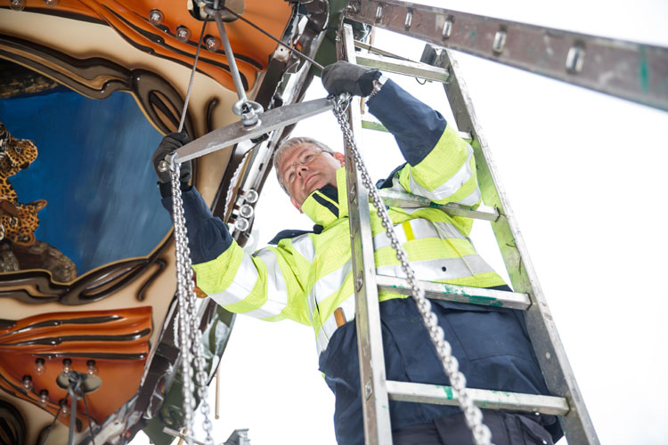 TÜV NORD employee Michael Krah checks the suspensions of the seats at the chairoplane.