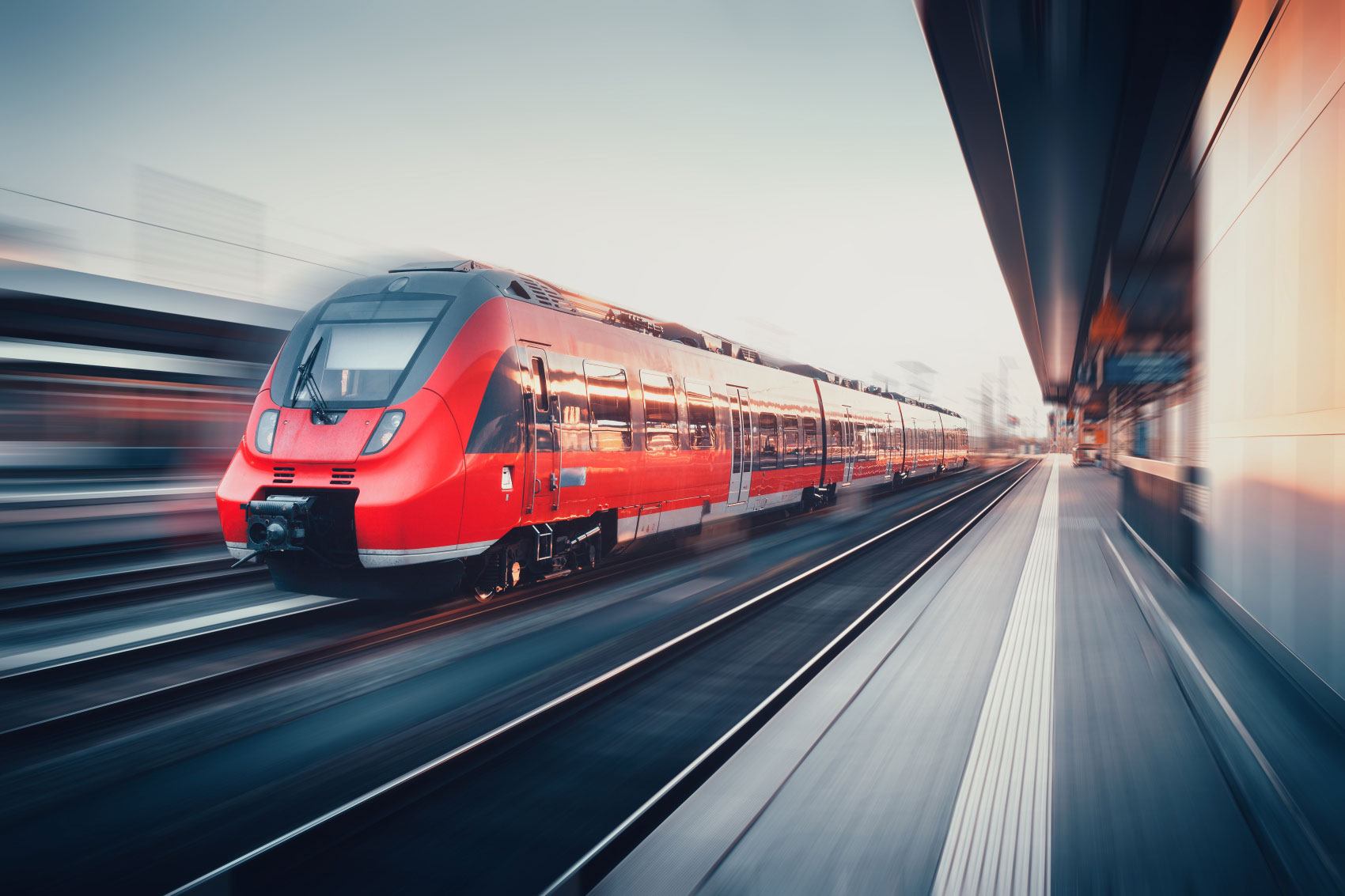 Roter Zug in Bewegung auf einem Bahnhof