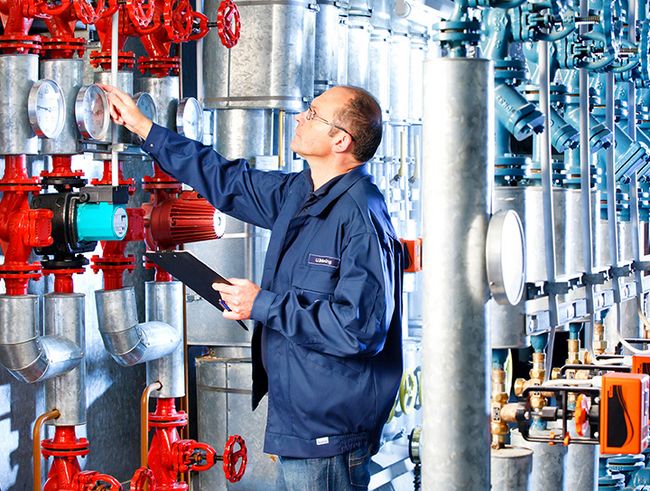 TÜV NORD Experte überprüft Messgeräte und Ventile in einer Industrieanlage.