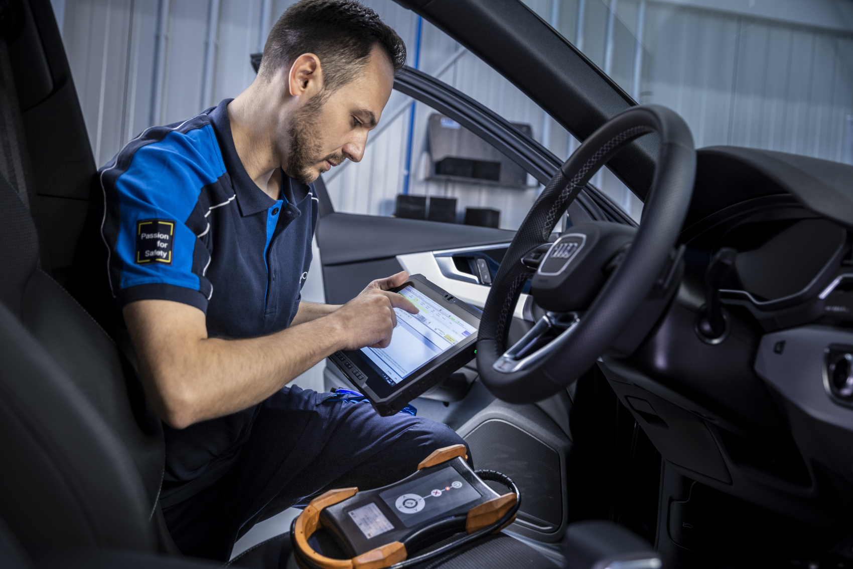 Prüfingenieur führt eine elektronische Fahrzeugdiagnose an der TÜV NORD Station durch