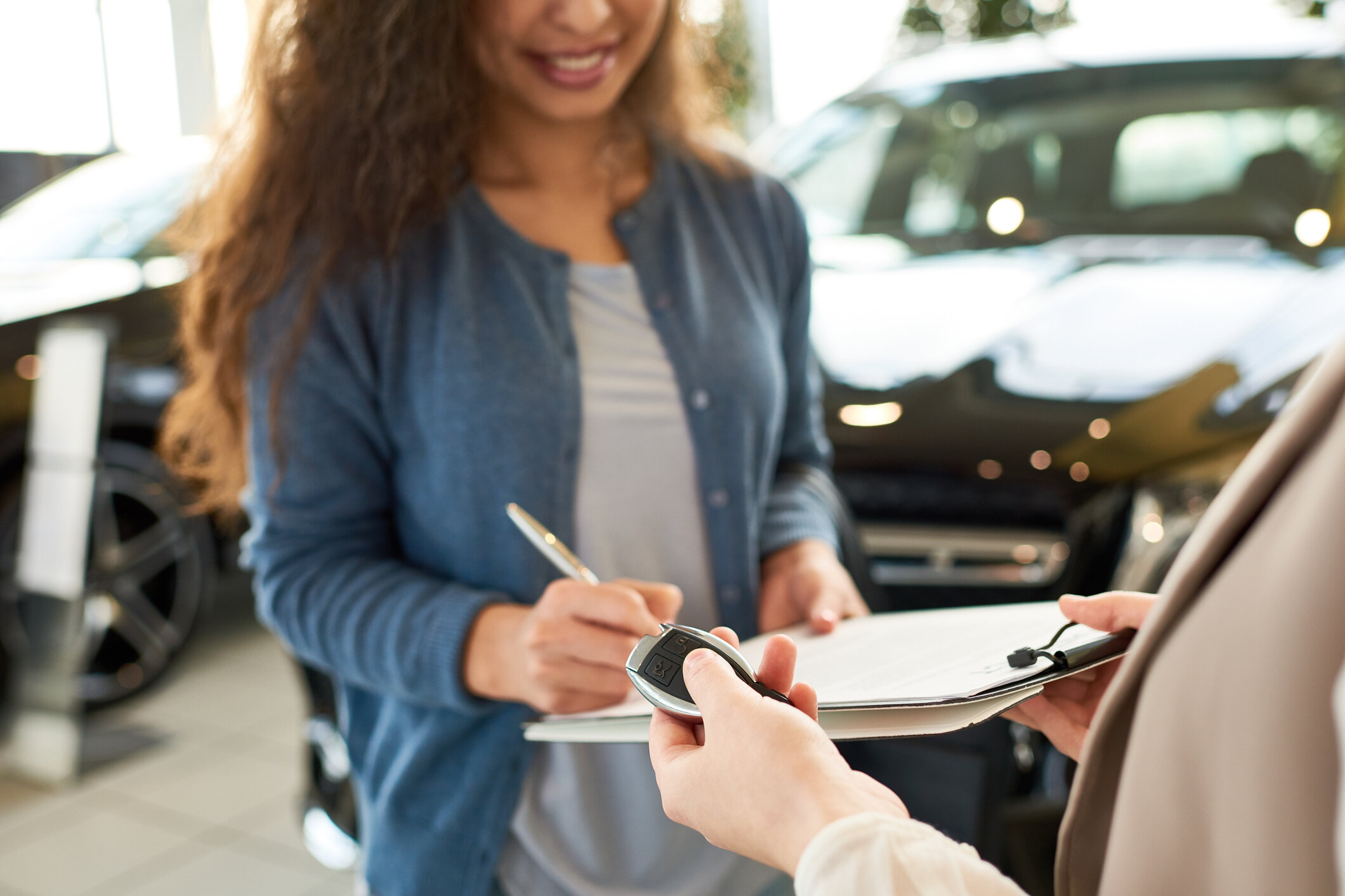 Übergabe von Autoschlüssel und Dokumenten im Autohaus