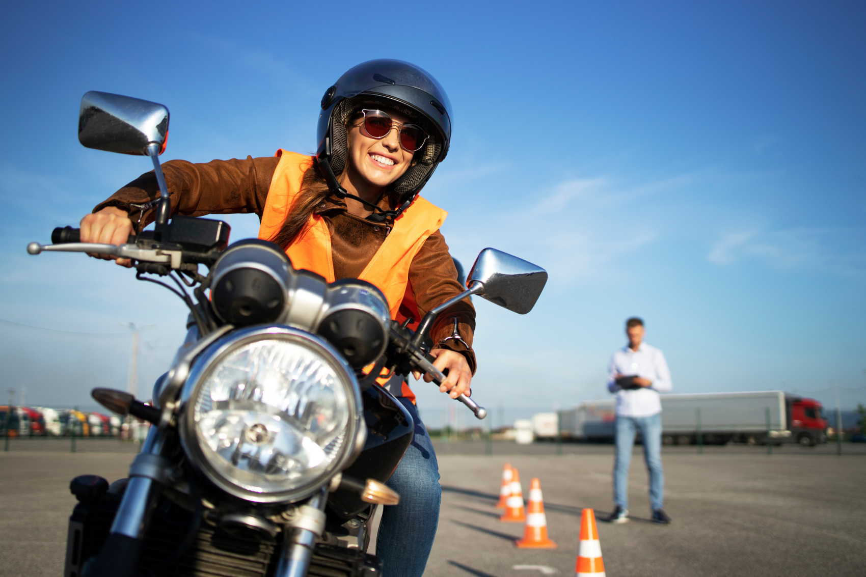 Motorradfahrer bei der Fahrprüfung mit einem Prüfingenieur im Hintergrund