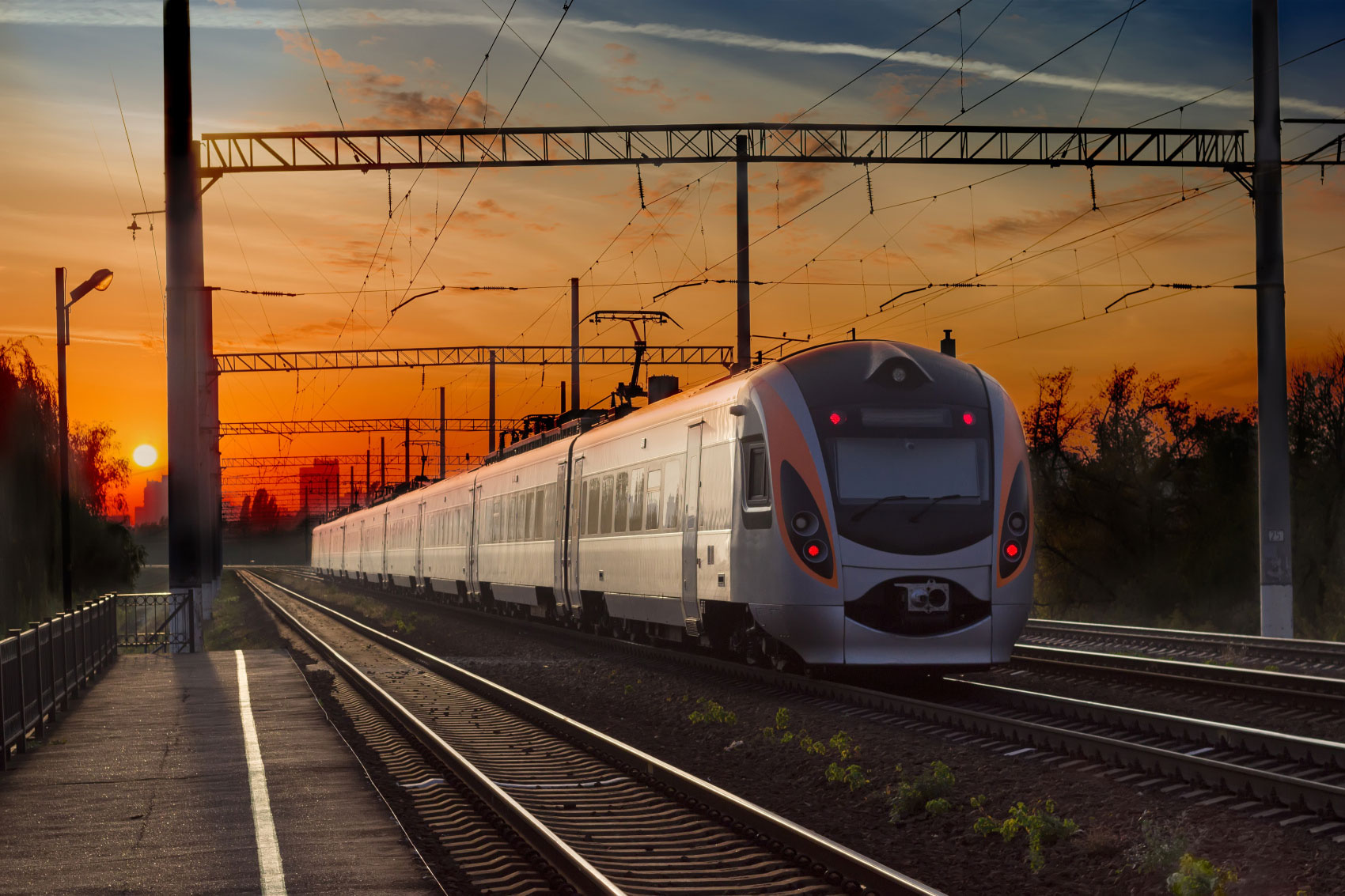 Moderner Zug bei Sonnenuntergang auf einer Bahnstrecke