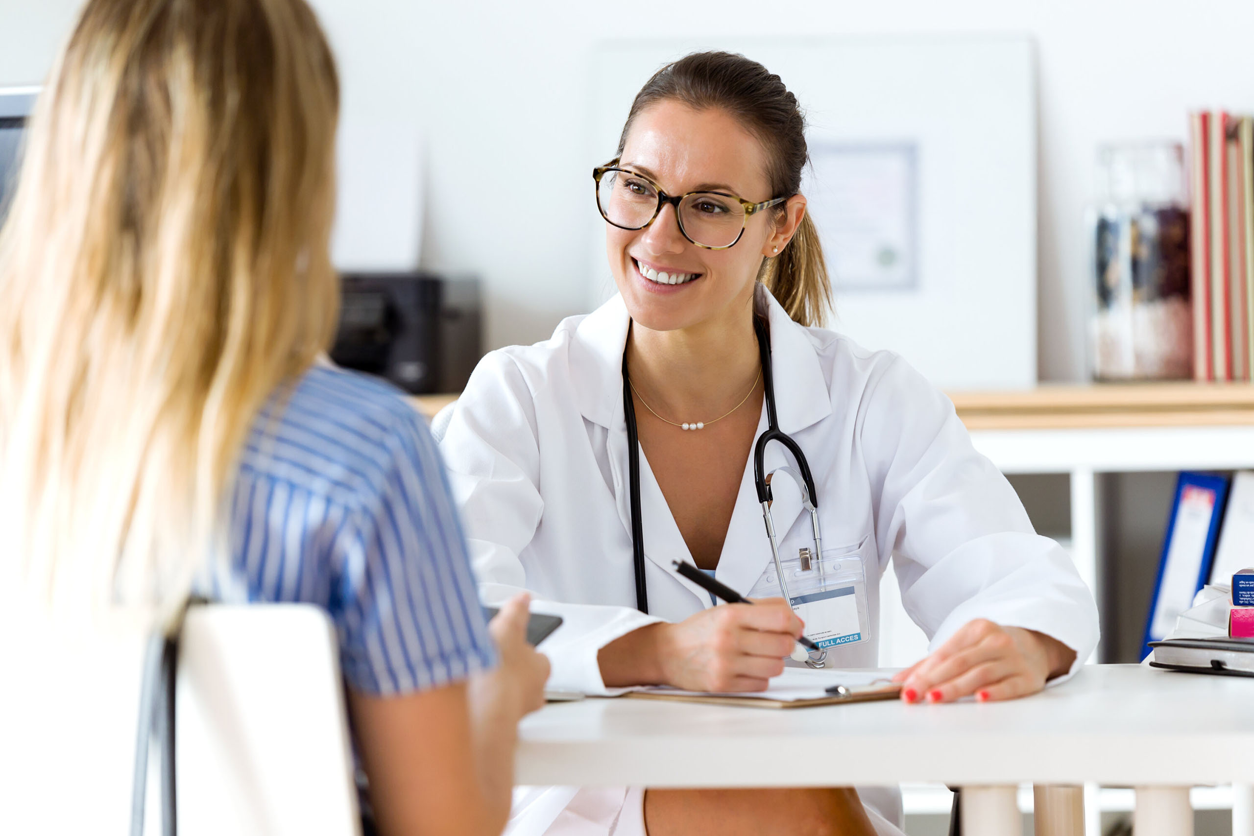 Eine Ärztin führt ein Gespräch mit einer Patientin und bietet Beratung zur Gesundheit am Arbeitsplatz