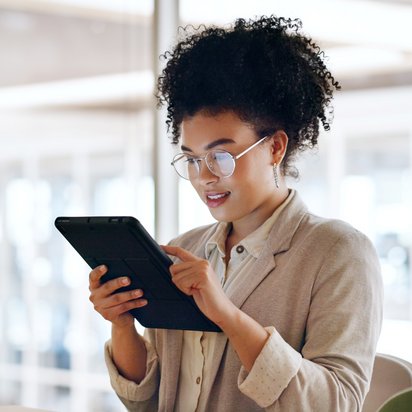 Person arbeitet an Laptop, umgeben von schwebenden digitalen Symbolen für Dokumente und Ordner.