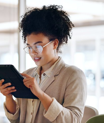Person arbeitet an Laptop, umgeben von schwebenden digitalen Symbolen für Dokumente und Ordner.