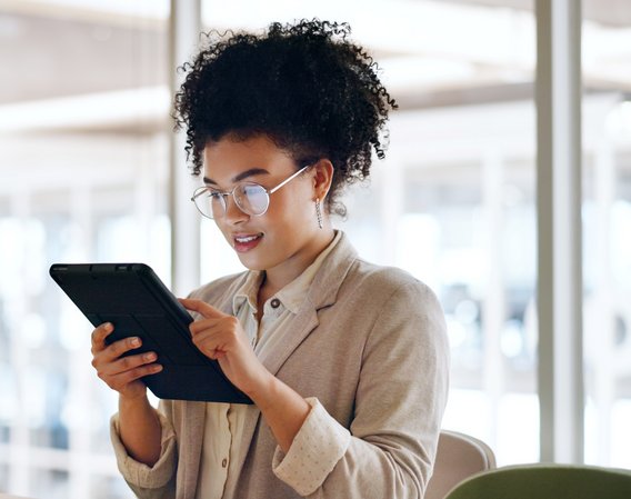 Person arbeitet an Laptop, umgeben von schwebenden digitalen Symbolen für Dokumente und Ordner.