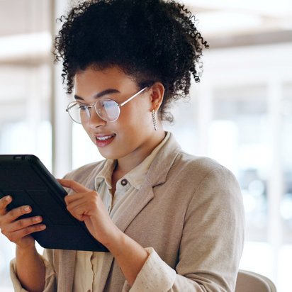 Person arbeitet an Laptop, umgeben von schwebenden digitalen Symbolen für Dokumente und Ordner.