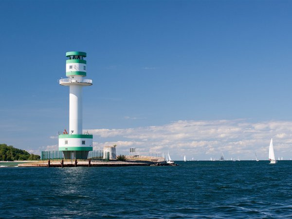 Leuchtturm in Kiel an der Ostsee mit Segelbooten und blauem Himmel