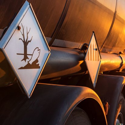 Sicherer Gefahrguttransport: ADR-Schulungen im Fokus Tanklastwagen mit Gefahrgutkennzeichnung bei Sonnenuntergang