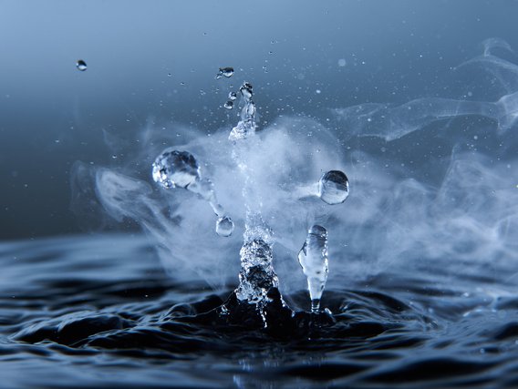 Nahaufnahme eines Wassertropfens der ins Wasser fällt