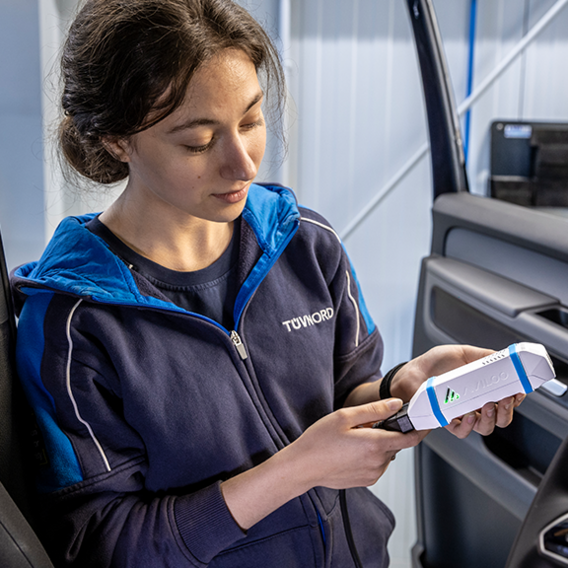 Prüfingenieurin mit Diagnosegerät an der TÜV NORD Station