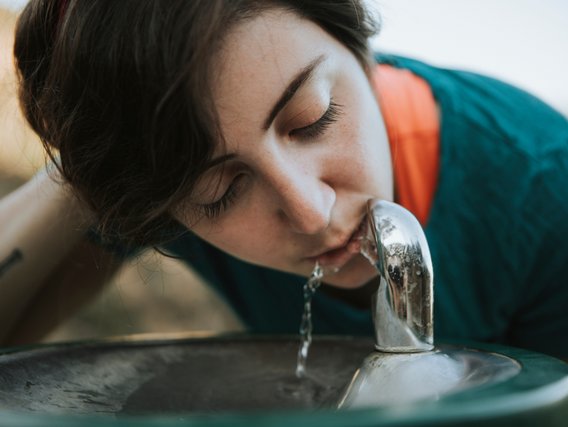 TUEV_NORD_Trinkwasserhygiene Frau trinkt aus einem Trinkwasserspender