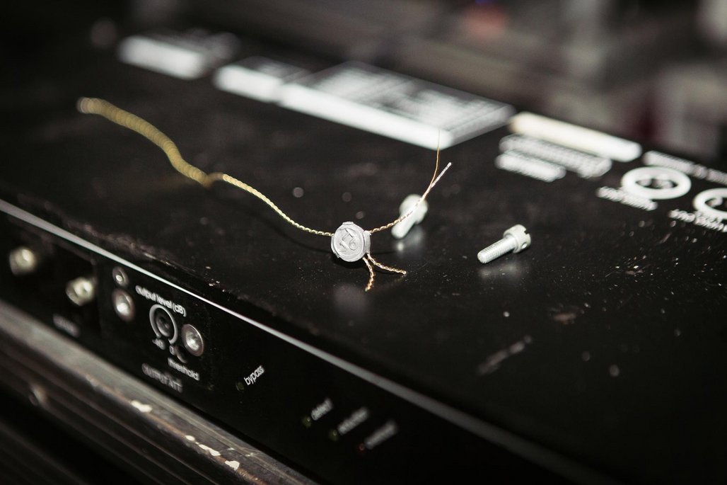 Nahaufnahme eines Audiogeräts mit freiliegenden Kabeln und einem Siegel oder Plombe, die technische Wartung oder Kalibrierung andeutet.