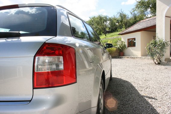 Silbernes Auto auf einem Kiesweg vor einem Landhaus