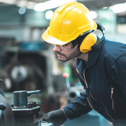 Eine Person in Schutzkleidung arbeitet an einer Maschine