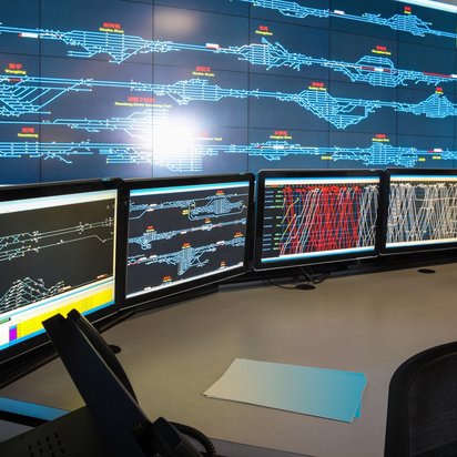 Kontrollraum mit mehreren Monitoren zur Überwachung von Verkehrssystemen