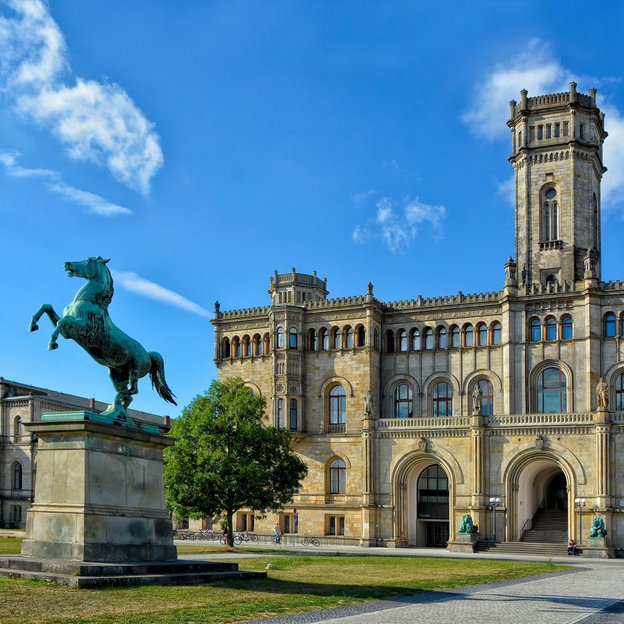 Das historische Gebäude der Universität Hannover mit dem Statue eines Pferdes im Vordergrund