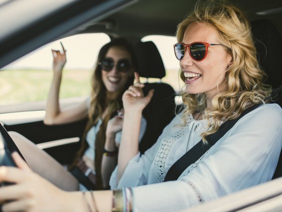 Frauen im Auto unterwegs Zwei Frauen im Auto, eine Frau am Steuer