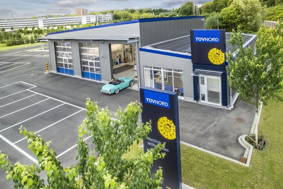 Außenansicht einer TÜV NORD Station mit Parkplatz