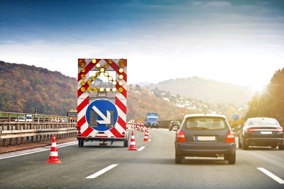 Verkehrssicherungsfahrzeug auf einer Autobahn mit Absperrungen und Verkehrskegeln