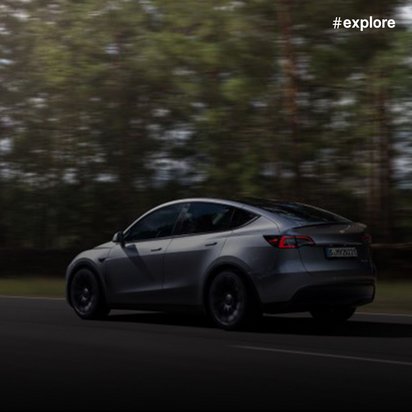 Ein modernes silbernes Auto fährt sehr schnell auf einer Straße mitten im Wald.