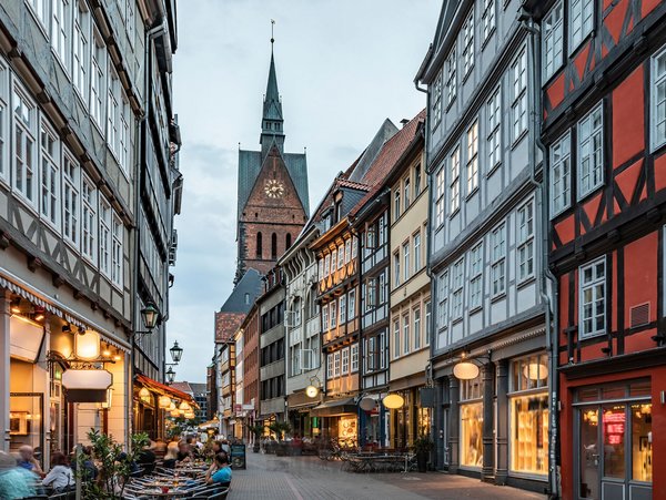 Straßenansicht von Hannover mit Fachwerkhäusern und der Stadtkirche im Hintergrund