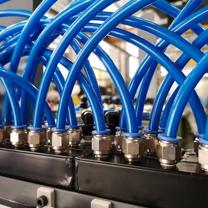 Vernetzte Systeme: Pneumatik-Lehrgänge im TÜV NORD Schulungszentrum Detailaufnahme von blauen pneumatischen Schläuchen in einem komplexen System.