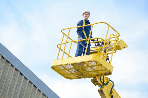 Arbeiter in Sicherheitskleidung auf einer Hebebühne während einer Schulung.