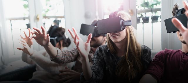 Eine Gruppe Jugendlicher sitzt mit VR-Brille auf der Couch
