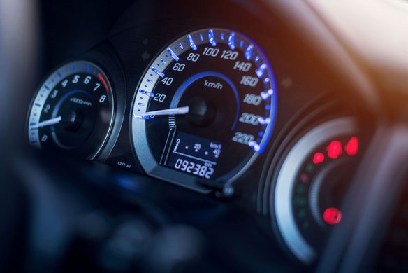 Nahaufnahme eines beleuchteten Tachometers in einem Fahrzeug