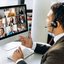 Videokonferenz Mann hält eine Videokonferenz mit mehreren Teilnehmern die auf dem Computermonitor zu sehen sind