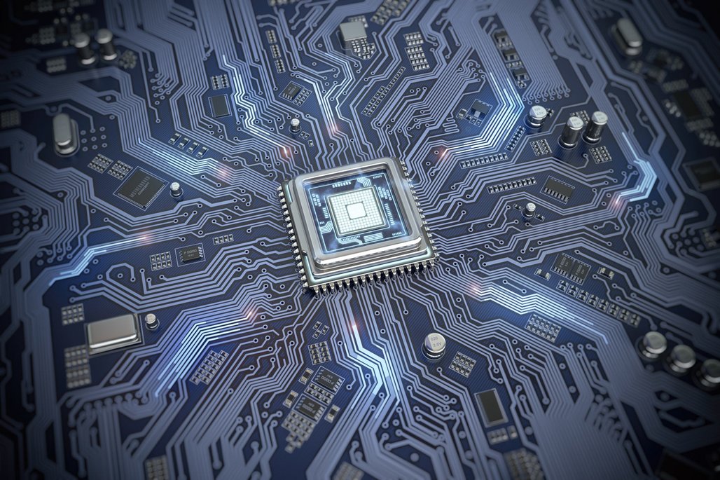 Nahaufnahme eines Computer-Prozessors oder Mikrochips im Zentrum einer blauen Leiterplatte. Die metallischen Leiterbahnen erstrecken sich strahlenförmig vom zentralen Chip zu verschiedenen elektronischen Komponenten.