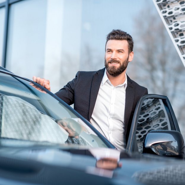 Ein Mann im Anzug steigt in ein Auto