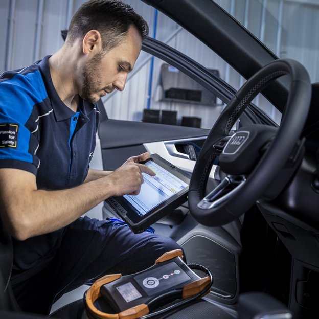 Prüfingenieur führt eine elektronische Fahrzeugdiagnose an der TÜV NORD Station durch