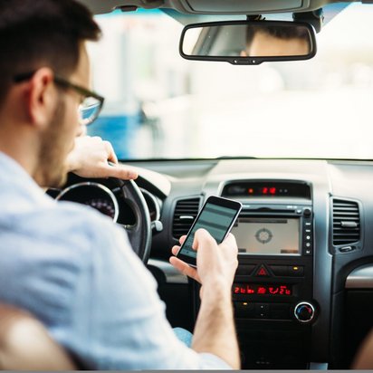 Fahrer nutzt Smartphone für digitale Unterstützung im Auto