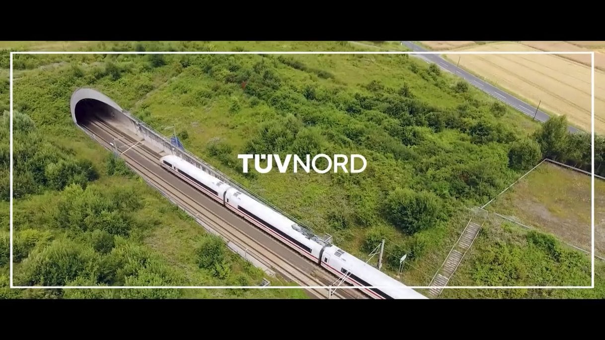 High-speed train leaves tunnel in green countryside