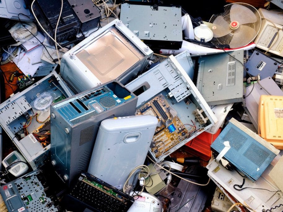 Durcheinander von alten Computer-Hardwareteilen, Gehäusen, Motherboards und elektronischen Komponenten in verschiedenen Grau- und Blautönen.