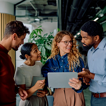 Revision ISO 14001 Zwei Männer und zwei Frauen betrachten Änderungen im Laptop