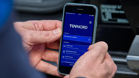 Smarthphone in einer Hand mit der TÜV NORD Onboard Diagnose App Oberfläche