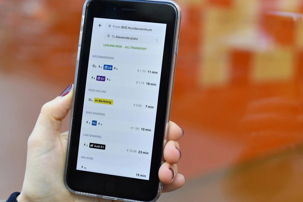 Smartphone-Display zeigt eine Mobilitäts-App mit verschiedenen Transportoptionen von BVG Kundenzentrum zu Alexanderplatz.