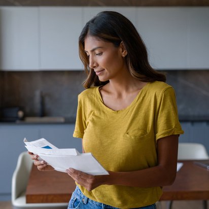 Frau, die Post öffnet und darin Informationen durchsieht.