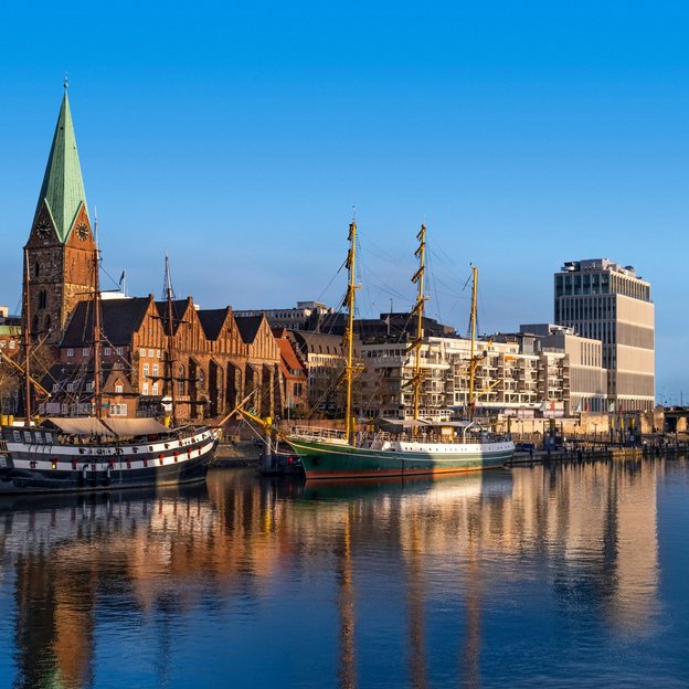 Segelschiffe am Ufer der Weser vor historischer Altstadt und modernen Gebäuden in Bremen