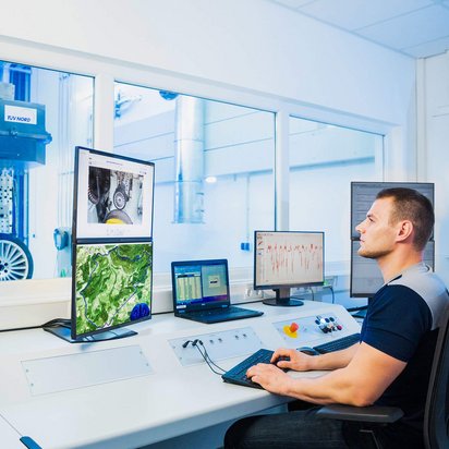 Ingenieur überwacht im IFM-Prüflabor von TÜV NORD auf mehreren Monitoren die Messdaten eines Prüfstands zur Prüfung sicherheitsrelevanter Fahrzeugbauteile und -systeme
