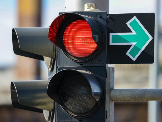 Eine Ampel mit rotem Licht ist an, und daneben zeigt ein grüner Pfeil nach rechts