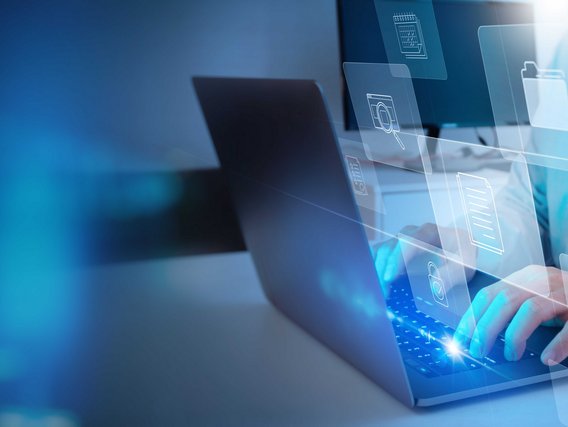 Person arbeitet an Laptop, umgeben von schwebenden digitalen Symbolen für Dokumente und Ordner.