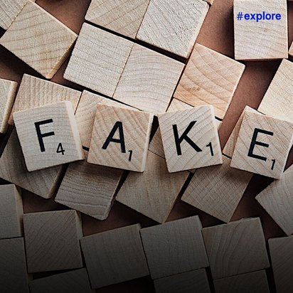 Das Bild zeigt Scrabble-Spielsteine aus hellem Holz, die das Wort "FAKE" buchstabieren. Die Buchstabensteine liegen auf einem Haufen weiterer Holzspielsteine