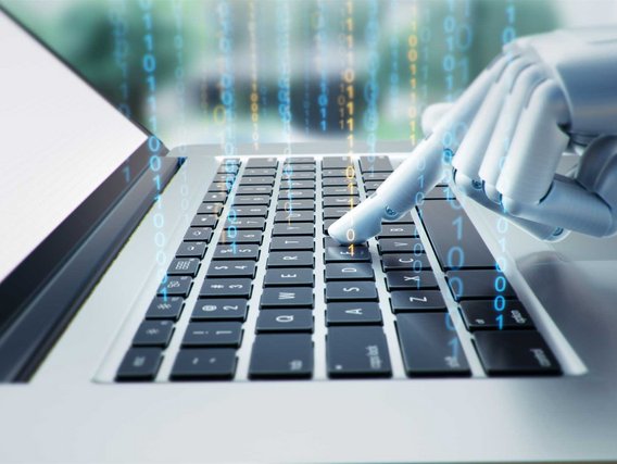 Eine weiße Roboterhand tippt auf einer Laptop-Tastatur, während im Hintergrund digitale blaue und grüne Datenströme mit Nullen und Einsen zu sehen sind.