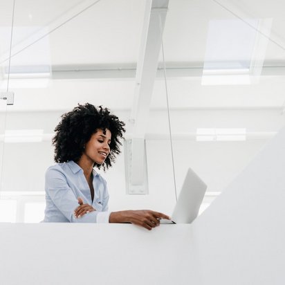 Person in einem modernen Büro mit Laptop, repräsentiert die innovative Arbeitsumgebung im TÜV NORD Schulungszentrum zur Förderung von Weiterbildungsmöglichkeiten.