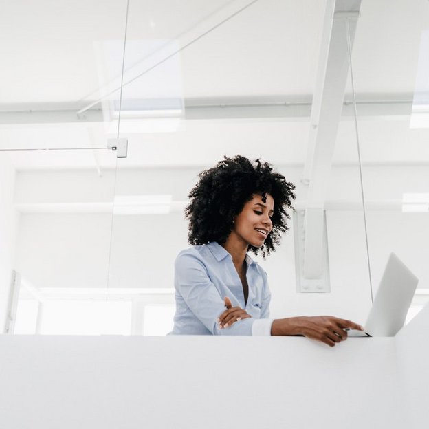 Person in einem modernen Büro mit Laptop, repräsentiert die innovative Arbeitsumgebung im TÜV NORD Schulungszentrum zur Förderung von Weiterbildungsmöglichkeiten.